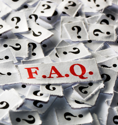 Scraps of paper with question marks surround a larger piece labeled "F.A.Q." in red letters.